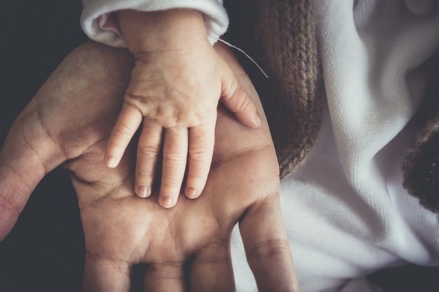 baby human hand on adult hand